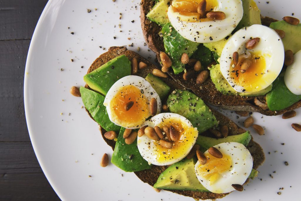 Des oeufs pochés sur un lit de salade d'avocat et de laitue pour un délicieux et sain dîne